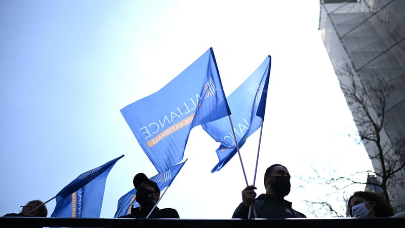 Des policiers brandissent le drapeau du syndicat Police Alliance Nationale lors d'une manifestation à Paris le 20 avril 2021.