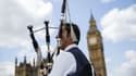 Un joueur de cornemuse écossais joue pour les touristes en face de Big Ben et du Parlement dans le centre de Londres, le 26 juin 2016. 