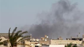 Colonne de fumée au dessus du complexe fortifiée Bab al Aziziah de Mouammar Kadhafi, à Tripoli. Des insurgés libyens ont pénétré mardi à l'intérieur de ce QG et ont tiré des coups de feu en l'air pour fêter l'événement. /Photo prise le 23 août 2011/REUTER