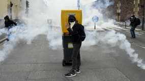 Un manifestant se tient derrière une poubelle pour se protéger des tirs de gaz lacrymogène des forces de l'ordre, lors d'une manifestation contre le projet de loi Travail à Rennes, le 17 mai 2016. 