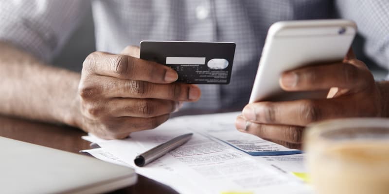 Un homme effectuant un virement bancaire depuis son téléphone (photo d'illustration).