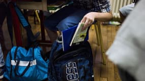 Un élève attrape un livre dans son sac, le 9 septembre 2014 à Paris