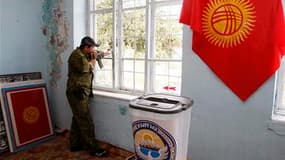 Dans un bureau de vote préparé pour le référendum de dimanche, un garde kirghize surveille la rue, dans la ville d'Och. Les autorités espèrent que le vote permettra de conforter leur pouvoir après le renversement du président Kourmanbek Bakiev en avril et