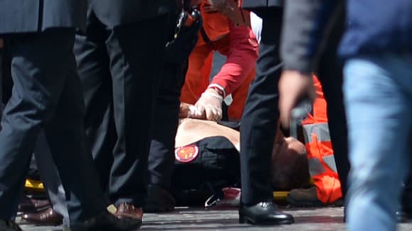 L'un des policiers blessés, à terre, après la fusillade.