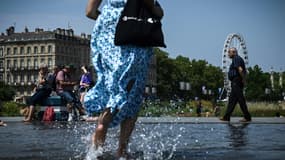 Une femme passe sur le Miroir d'eau, le 28 juillet 2024 à Toulouse 