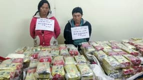 Deux trafiquants, photographiés ici lors de leur arrestation le 2 janvier 2018 dans un poste de police au Vietnam, ont tenté de faire passer pour près de 2,5 millions d'euros d'héroïne dans des sachets de thé, une prise record pour le pays