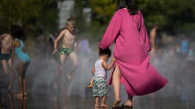 Des personnes se rafraîchissent avec l'eau d'une fontaine, alors que la température de l'air dépasse les 42 degrés Celsius à Nantes, le 18 juillet 2022.