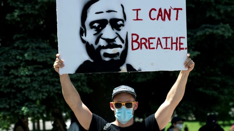 Un manifestant porte une pancarte à l'effigie de George Floyd, le 30 mai 2020 à Denver, dans le Colorado, avec ses derniers mots: "Je ne peux pas respirer"
