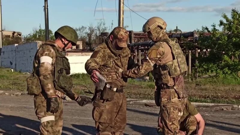Un soldat ukrainien fouillé par des Russes après s'être rendu à Marioupol le 17 mai 2022