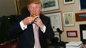 Donald Trump goûte une pizza, en avril 2005, dans les bureaux de sa Trump Tower, à New York. 