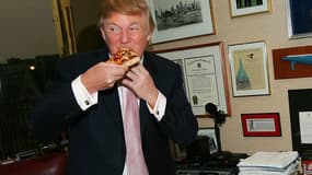 Donald Trump goûte une pizza, en avril 2005, dans les bureaux de sa Trump Tower, à New York. 