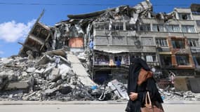 Une Palestinienne passe devant un immeuble détruit à Gaza par les bombardements israéliens, le 22 mai 2021 