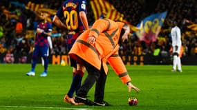 Un stadier ramassant un ballon jeté des tribunes lors du Clasico Barça-Real, au Camp Nou de Barcelone le 18 décembre 2019