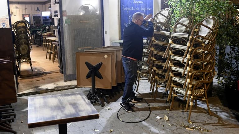 Un restaurateur empile son mobilier de terrasse.