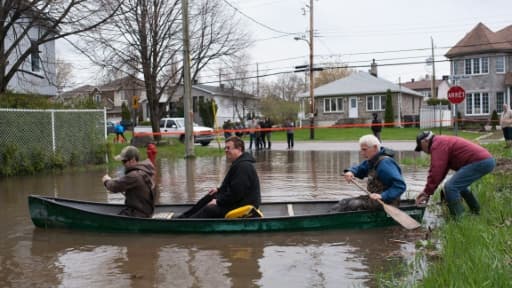 Des habitants de Pierrefonds se déplacent en barque lors d'inondations au Québec, le 7 mai 2017