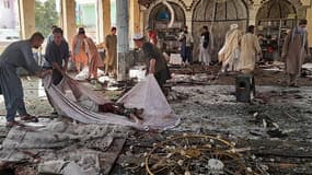 Des hommes afghans se préparent à transporter le corps d'une victime à l'intérieur d'une mosquée chiite après une attaque à la bombe dans la province de Kunduz, le 8 octobre 2021.