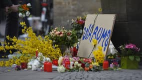 "Pourquoi?", peut-on lire sur une pancarte déposée là où un homme a tué deux personnes et en a blessé une vingtaine d'autres, lançant sa camionnette sur la terrasse d'un café de Münster, en Allemagne. 