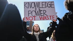Une manifestante tient une pancarte "la connaissance c'est le pouvoir, pas du gaspillage" lors du rassemblement Stand up for Science à New York le 7 mars 2025