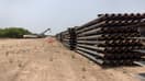 Des poteaux en acier inutilisés reposent près d'une partie du mur frontalier inachevé à la frontière entre les États-Unis et le Mexique, le 14 avril 2021 à La Joya (Texas).
