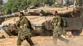 Des soldats israéliens passent devant un tank Merkava à la frontière sud de la bande de Gaza, le 1er août 2014.