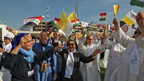 Des soeurs agitent des drapeaux irakiens, du Kurdistan et du Vatican, en attendant le pape à Erbil le 7 mars 2021
