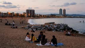 Des jeunes sur la plage de Barcelone à la tombée de la nuit, le 30 mai 2020 en Espagne