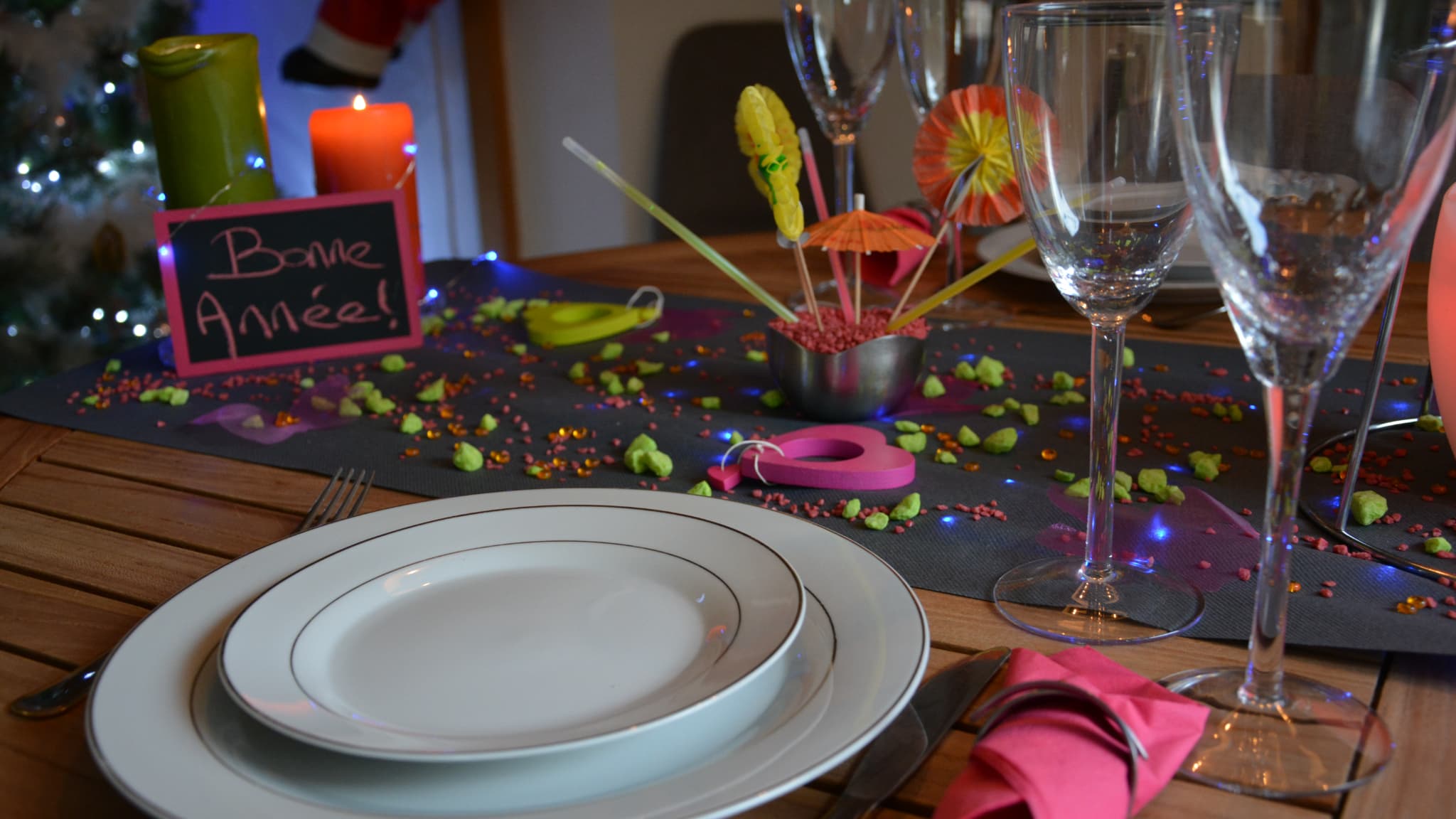 Une table de réveillon du 31 décembre, recouverte de bougies et de petites décorations.