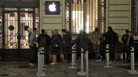 Des clients font la queue devant un Apple Store à Paris