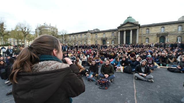Une jeune femme s'adresse à la foule sur la place de la République de Bordeaux.