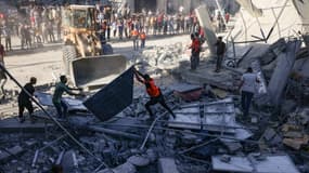 Des secours évacuent des gravats sur un immeuble bombardé de Rafah sur la bande de Gaza, le 26 octobre 2023