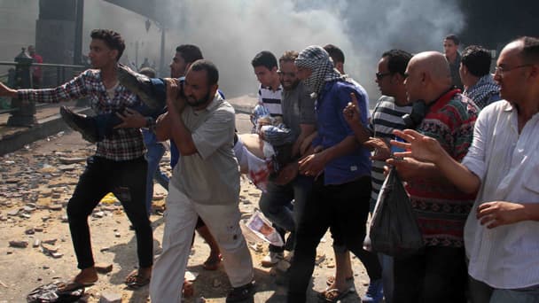 Des partisans de Mohamed Morsi évacuent un blessé, ce vendredi au Caire.