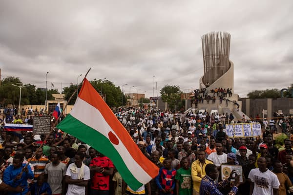 Des manifestants brandissent un drapeau nigérien lors d'une manifestation à l'occasion de la fête de l'indépendance à Niamey, le 3 août 2023.