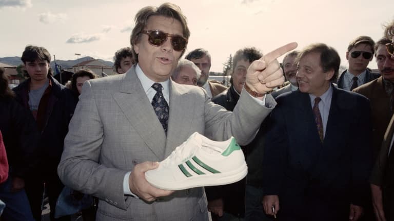 Bernard Tapie photographié le 16 mars 1992 avec une chaussure Adidas en main, au marché de Plan-de-Cuques, près de Marseille, lors de la campagne des élections régionales