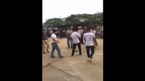 Sur un chantier en Chine, un ouvrier gare des voitures avec une pelleteuse