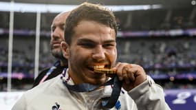 Le rugbyman Antoine Dupont croque à pleines dents dans sa médaille d'or des JO de Paris, le 27 juillet 2024