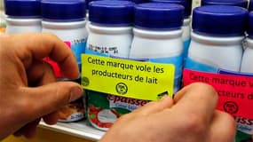 Un producteur de lait en colère appose des slogans sur les produits d'un supermarché mardi à Saint-Herblain, près de Nantes. Réunis mercredi à Paris, les syndicats de producteurs de lait ont donné aux industriels jusqu'au 12 août pour payer la tonne de la