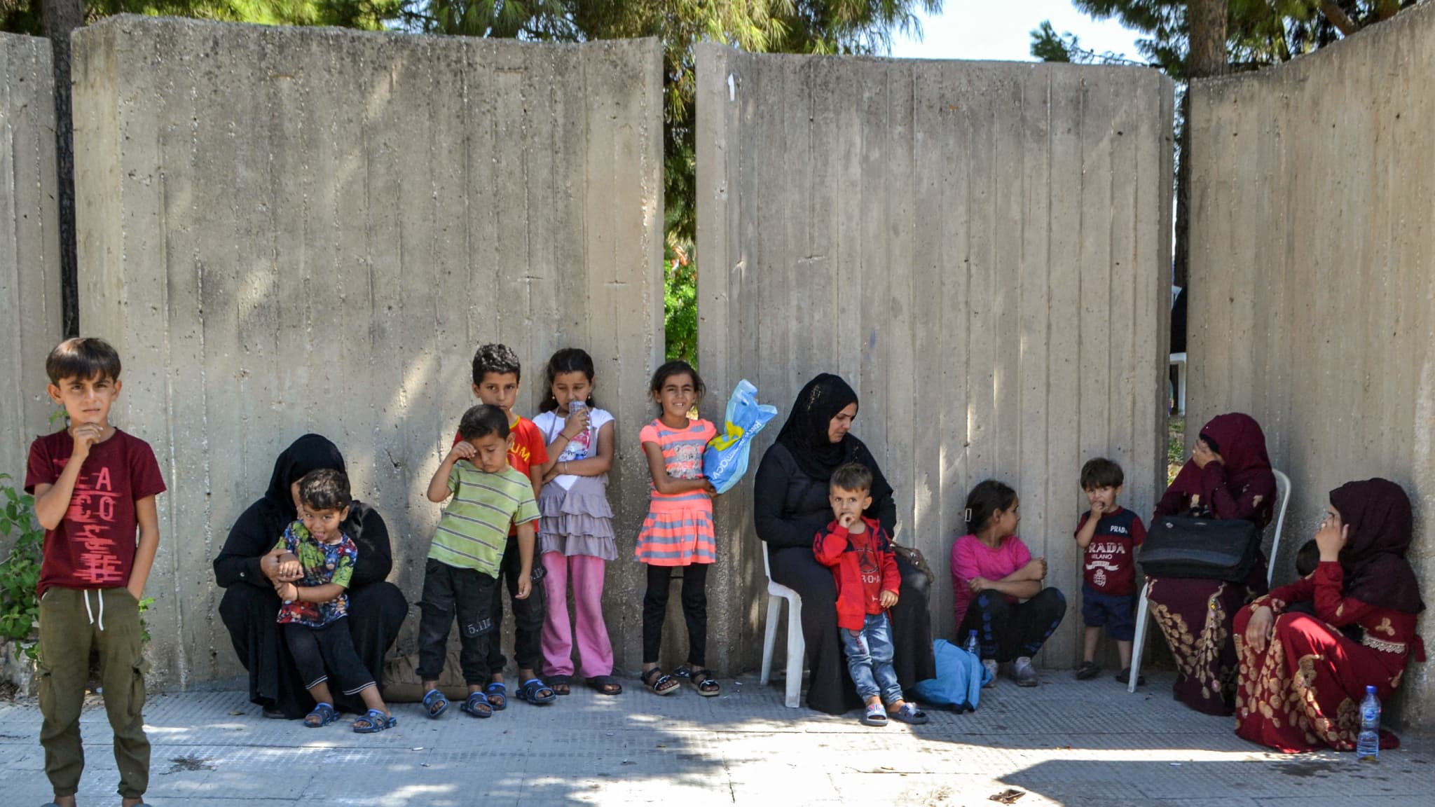 Des personnes déplacées du Sud-Liban par le conflit attendent devant un centre d'accueil temporaire dans la ville de Tripoli, au nord du pays, le 25 septembre 2024.