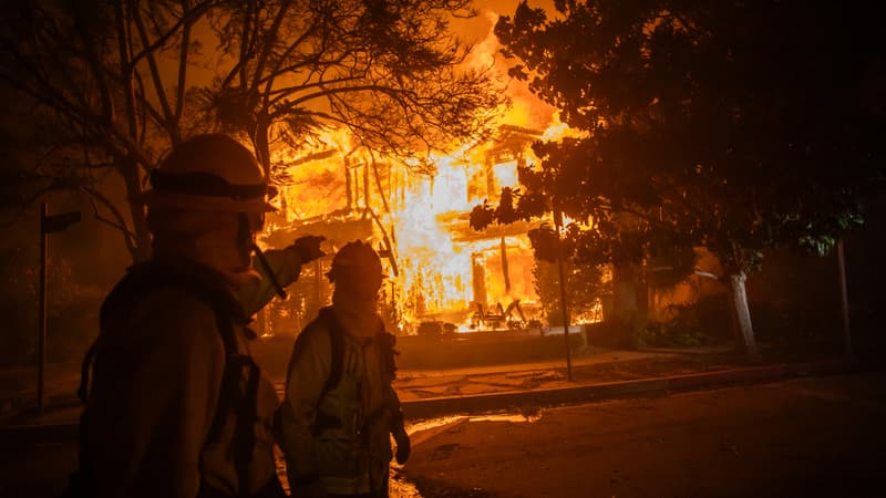Un pompier passe devant une maison en flammes suite à l'incendie de Palisades lors d'une puissante tempête de vent le 8 janvier 2025 dans le quartier de Pacific Palisades à Los Angeles, en Californie.