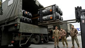 Des soldats ukrainiens chargent sur un camion des missiles FGM-148 Javelin anti-tanks livrés par avion par les Etats-Unis à l'aéroport Boryspil de Kiev, le 11 février 2022.