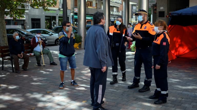 Des membres de la défense civile informent des passants sur les nouvelles restrictions de mouvement à Madrid le 21 septembre 2020