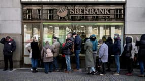 Des personnes font la queue devant une succursale de la banque publique russe Sberbank pour y retirer leurs avoirs et fermer leurs comptes à Prague, le 25 février 2022
