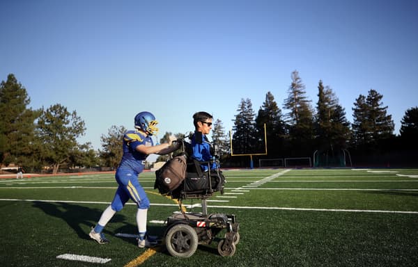 Rob Mendez poussé sur son fauteuil par un de ses joueurs de la Prospect High School lors de la saison 2018