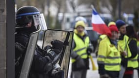 Un CRS face à des gilets jaunes