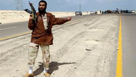 Rebelle libyen sur la route entre Benghazi et Ajdabiah. La coalition internationale a bombardé dans la nuit de dimanche à lundi les forces de Mouammar Kadhafi près d'Ajdabiah, dans l'est de la Libye, et les insurgés font route vers cette ville stratégique