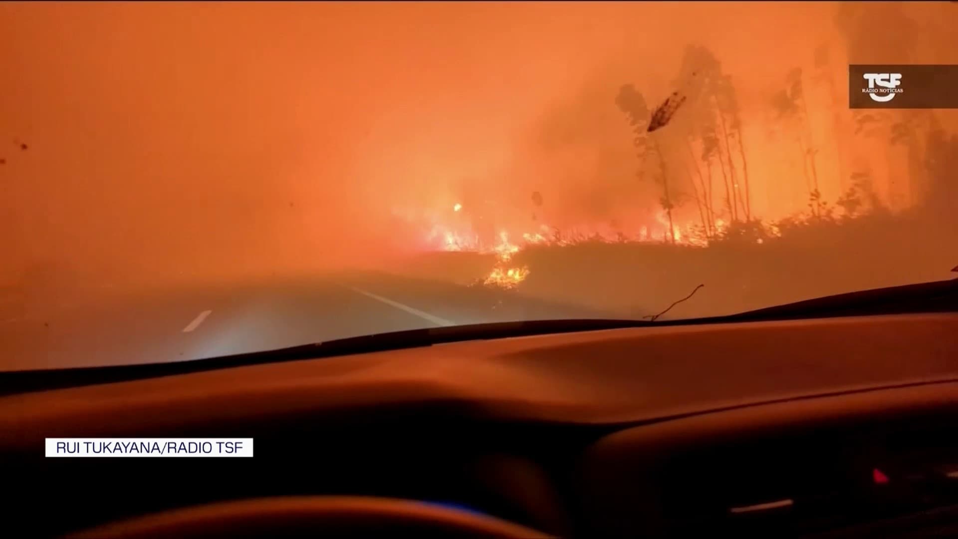 A journalist is photographed crossing the fire in the middle of the highway