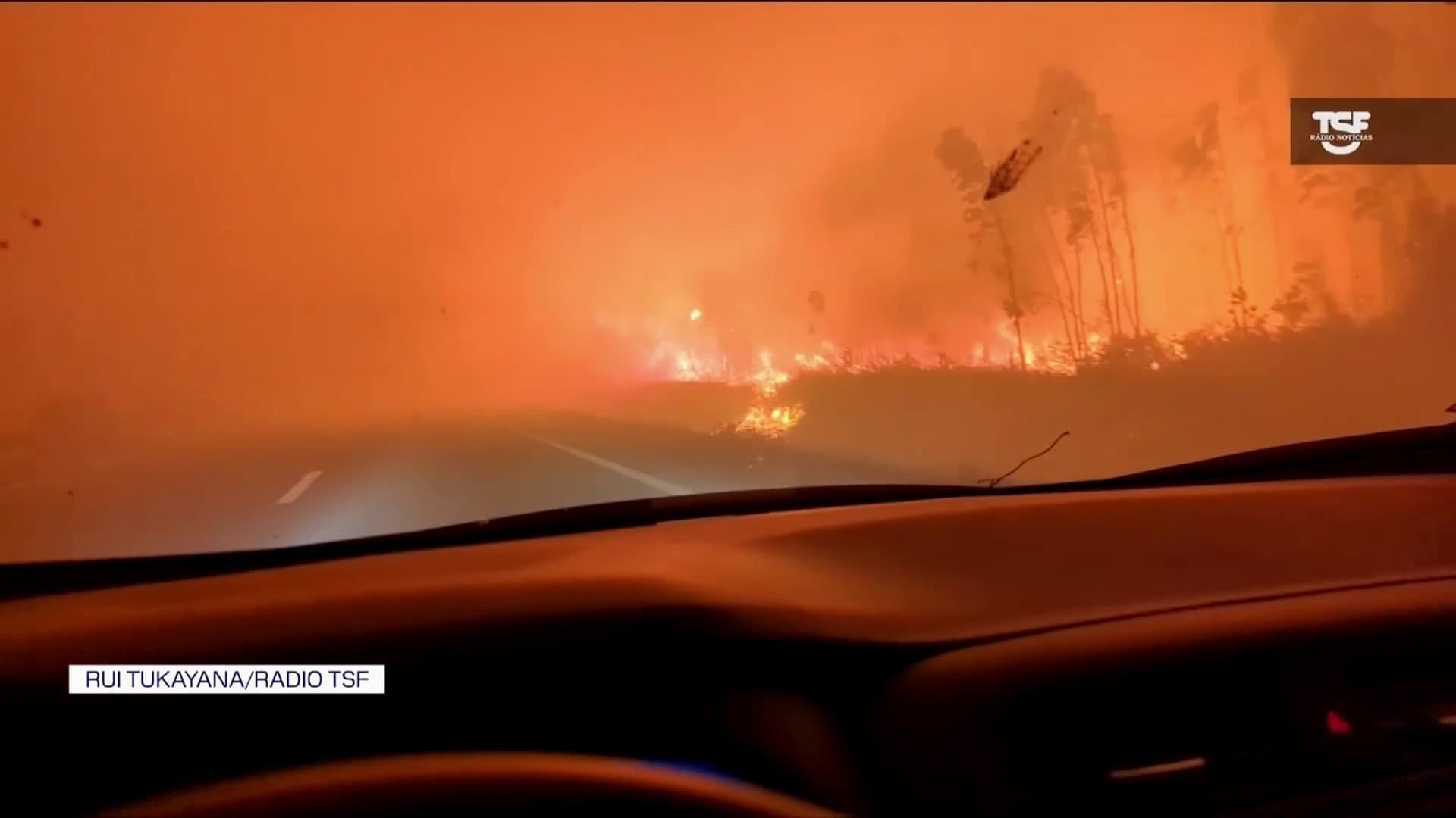 un periodista filma su cruce de un incendio en medio de la carretera