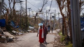 Une femme transporte de l'eau à Pamandzi (Mayotte), le 17 décembre 2024.