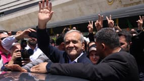 Le candidat à la présidence iranienne et réformateur Massoud Pezeshkian réagit à la foule à l'extérieur d'un bureau de vote où il a voté lors de l'élection présidentielle à Téhéran, le 28 juin 2024.