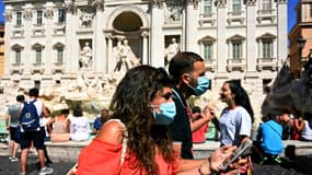 Des touristes le 19 août 2020 devant la Fontaine de Trevi à Rome: depuis lundi, le port des masques est  obligatoire en Italie le soir dans les lieux publics fréquentés 