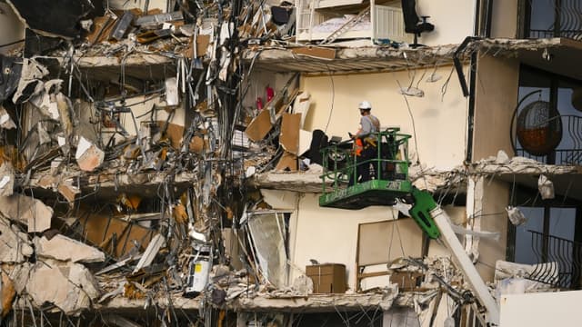 Des secouristes sur une grue devant le reste de l'immeuble qui s'est effondré à Surfside, en Floride, le 25 juin 2021.